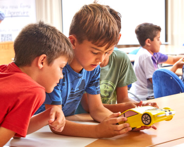 Two boys looking at toy car