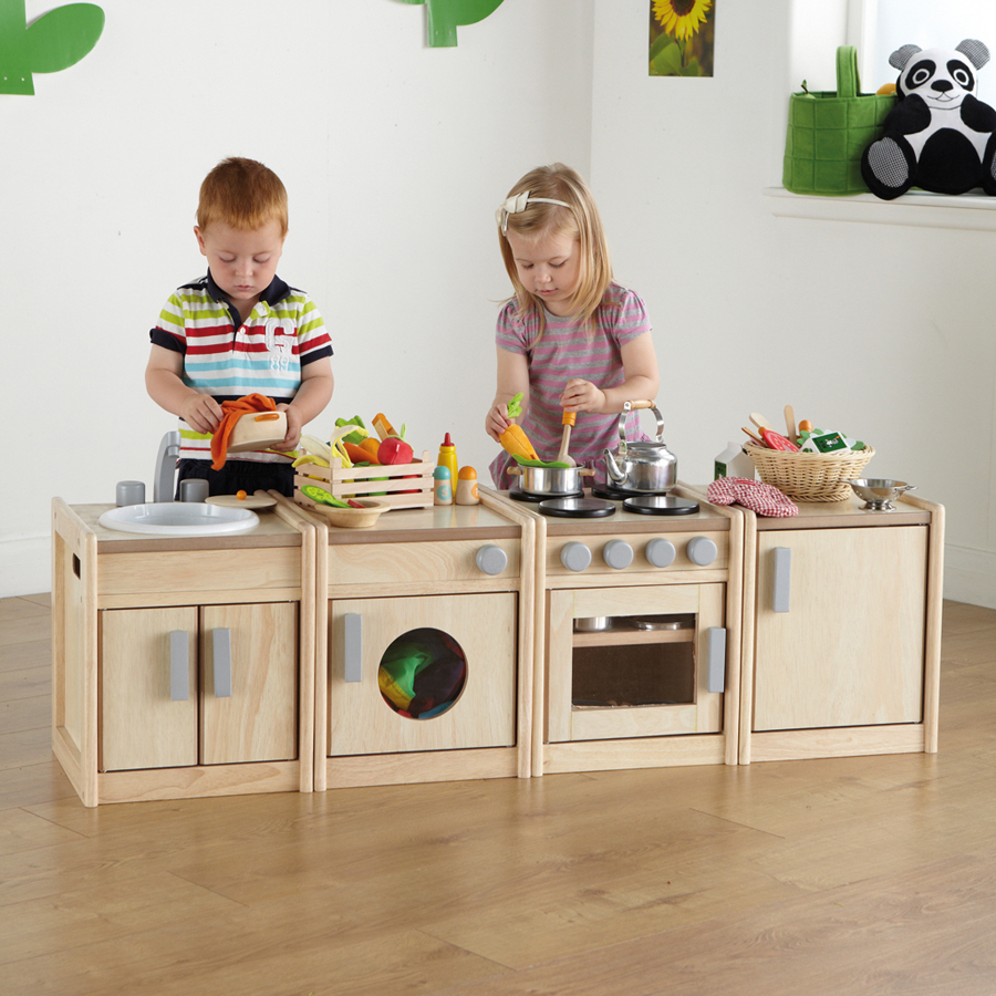 A young boy and girl play with wooden play kitchen
